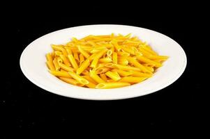 een wit bord gevulde met geel pasta foto