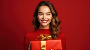 mooi meisje staand Aan een rood achtergrond met een geschenk in de handen foto