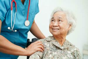 dokter helpen Aziatisch ouderen vrouw onbekwaamheid geduldig zittend Aan rolstoel in ziekenhuis, medisch concept. foto