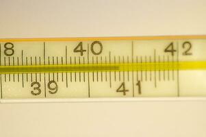 kwik thermometer tonen een koorts in detailopname Aan een glad achtergrond foto