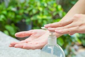 vrouw handen gebruik makend van wassen hand- ontsmettingsmiddel gel pomp dispenser. foto