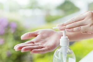 vrouw handen gebruik makend van wassen hand- ontsmettingsmiddel gel pomp dispenser. foto