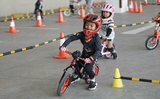 depok-indonesië, 29 07 2023 - Indonesisch kinderen van 2-5 jaren oud races Aan balans fiets in een parkeren Oppervlakte, sportiviteit opleiding foto