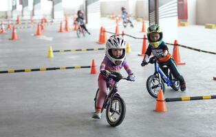depok-indonesië, 29 07 2023 - Indonesisch kinderen van 2-5 jaren oud races Aan balans fiets in een parkeren Oppervlakte, sportiviteit opleiding foto