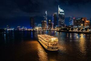 ho chi min, viet naam - 3 augustus 2023 ho chi minh stad horizon en de Saigon rivier. verbazingwekkend kleurrijk nacht visie van wolkenkrabber en andere modern gebouwen foto