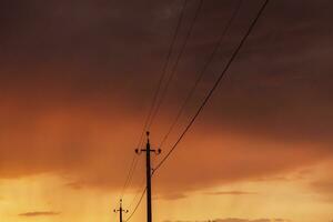 hoog voltage macht lijnen Bij zonsondergang. elektriciteit distributie station. elektriciteit pylonen Aan de achtergrond van de lucht foto