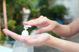 vrouw handen gebruik makend van gel pomp dispenser wassen hand- ontsmettingsmiddel. foto