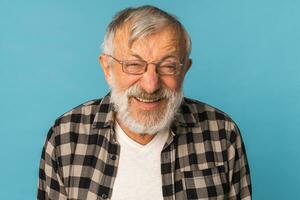 detailopname portret gepensioneerd oud Mens met wit haar- en baard gelach opgewonden over- blauw kleur achtergrond foto