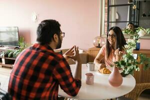 gelukkig Indisch paar hebben ontbijt en klein praten samen in de keuken - vriendschap, dating en familie foto