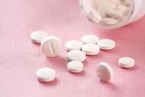 close-up van velen terwijl gekleurde medische pillen op roze morsen