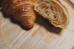 de croissants worden op een houten ondergrond geplaatst. gebakken goederen op geïsoleerde achtergrond foto