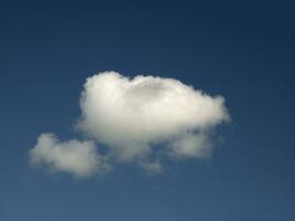 single wit wolk over- blauw lucht achtergrond. pluizig cumulus wolk vorm foto