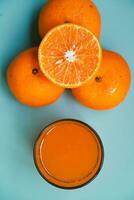 vlak leggen van een weinig stukken van oranje fruit Aan een blauw tafel achtergrond foto