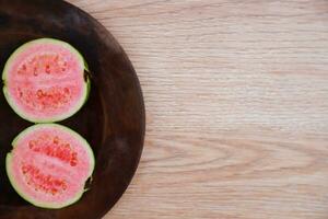 vlak leggen van voor de helft besnoeiing vers guava Aan de tafel foto