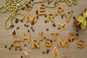 vrolijk Kerstmis woord gemaakt van koekjes en koffie bonen Aan houten achtergrond foto