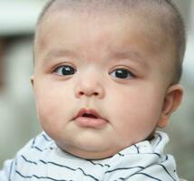 schattig Aziatisch Pakistaans baby jongen is poseren in de huis tuin gedurende bewolkt dag over- luton, Engeland uk. beeld was gevangen genomen Aan juli 23e, 2023 foto