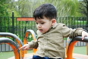 schattig Aziatisch Pakistaans baby is genieten van de mooi zonnig dag Bij afweren kinderen en openbaar park van luton stad- van Engeland uk. laag hoek beeld was gevangen genomen Aan april 03e, 2023 foto