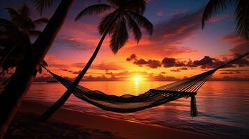 prachtig zonsondergang over- een tropisch strand met palm bomen en een hangmat. silhouet concept foto