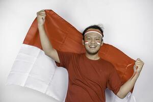 gelukkig glimlachen Indonesisch Mens Holding Indonesië's vlag naar vieren Indonesië onafhankelijkheid dag geïsoleerd over- wit achtergrond. foto