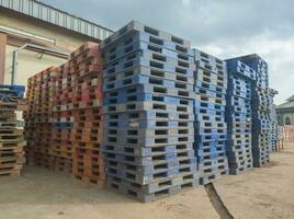 stapel van vuil plastic pallets, concept foto van faillissement onderhoud lading vervoer industrie onderhoud