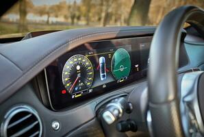 auto stuurinrichting wiel met auto dashboard computer en interieur achtergrond, modern stad auto elementen dichtbij visie. auto binnen interieur foto