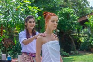 jong mooi vrouw genieten van massage in tropisch tuin. foto