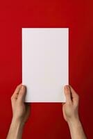 een menselijk hand- Holding een blanco vel van wit papier of kaart geïsoleerd Aan rood achtergrond. ai gegenereerd foto