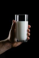 hand- Holding een glas van vers melk geïsoleerd Aan zwart achtergrond. ai gegenereerd foto