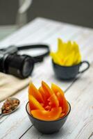 een kom van papaja augurk Aan een tafel foto