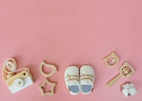 direct bovenstaand van baby accessoires Aan roze achtergrond, schattig houten baby speelgoed. foto