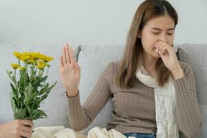 stuifmeel allergieën, Aziatisch jong vrouw niezen in een zakdoek of blazen in een veeg, allergisch naar wild voorjaar bloemen of bloesems gedurende de lente. allergisch reactie, ademhalings systeem problemen foto