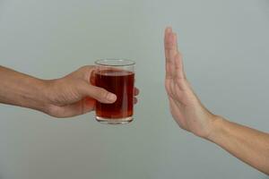 Mens weigert zeggen Nee en vermijden naar drinken een alcohol whisky , stoppen hand- teken mannelijk, alcoholisme behandeling, alcohol verslaving, stoppen drank, hou op drinken alcohol. weigeren glas likeur, ongezond, afwijzen foto