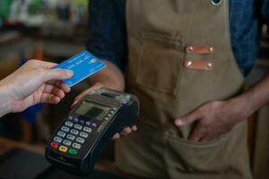 vrouw gebruik credit kaart betalen geld online in cafe restaurant met een digitaal betaling zonder contant geld. accumuleren korting. e portemonnee, technologie, betalen online, credit kaart, bank app. dagelijks leven betaling foto