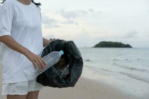 opslaan water. vrijwilliger plukken omhoog uitschot vuilnis Bij de strand en plastic flessen zijn moeilijk ontleden voorkomen kwaad aquatisch leven. aarde, omgeving, vergroening planeet, verminderen globaal opwarming, opslaan wereld foto