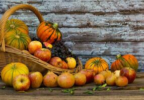 mand vol van fruit en herfst bloemen foto