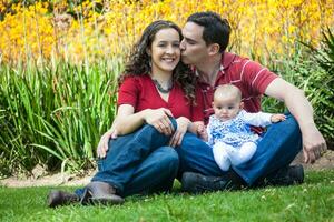 jong ouders hebben pret buitenshuis met hun zes maanden oud baby meisje. geluk concept. familie concept foto