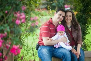 jong ouders hebben pret buitenshuis met hun zes maanden oud baby meisje. geluk concept. familie concept foto