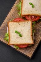 heerlijk belegd broodje met geroosterd brood, ham, tomaten, kaas en sla foto