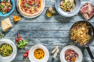 top van visie vol tafel van Italiaans maaltijden Aan borden en pan. pizza pasta risotto soep en vis groente salade foto