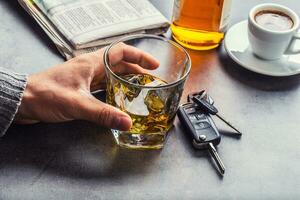 glas van alcohol hand- Mens de sleutels naar de auto en onverantwoordelijk bestuurder foto