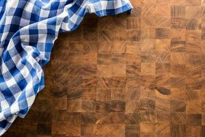 top van visie blauw geruit tafelkleed Aan houten bord. foto