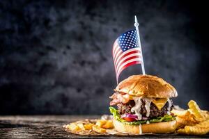 detailopname huis gemaakt rundvlees hamburger met Amerikaans vlag en Patat Aan houten tafel foto