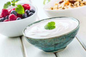 muesli yoghurt en bessen. gezond ontbijt met yoghurt muesli en vers fruit foto