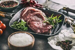 rundvlees ribe oog steak in rooster pan met rozemarijn oregano zout peper specerijen knoflook en tomaten foto