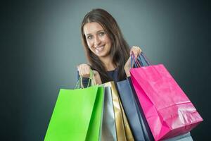 portret van jong gelukkig glimlachen vrouw met boodschappen doen Tassen credit kaart en schoenen. foto