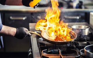 detail van een flambe in een pan met vlammen bereiken hoog foto