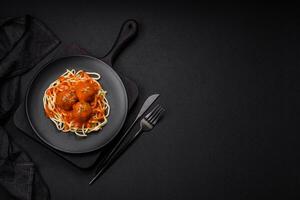 heerlijk vers gehaktballen en pasta in tomaat saus met zout, specerijen en kruiden foto