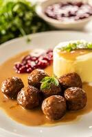 bord portie Zweeds gehaktballen kottbullar in saus met gepureerd aardappelen en veenbes saus foto