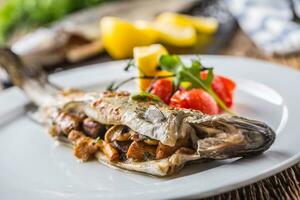 vis forel met champignons en groente Aan bord in hotel of restaurant foto