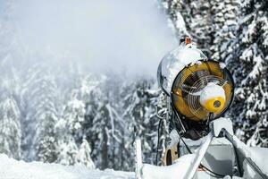 sneeuw kanon geweer of machine sprays water en sneeuwt een ski of cross-country bijhouden foto
